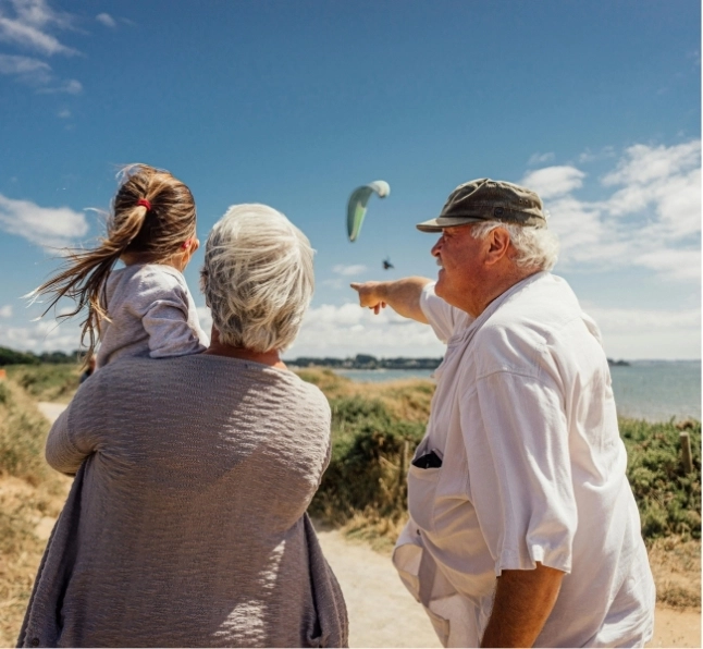 Grandparents take their grandchild to the beach