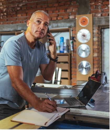 Man takes notes during a phone call